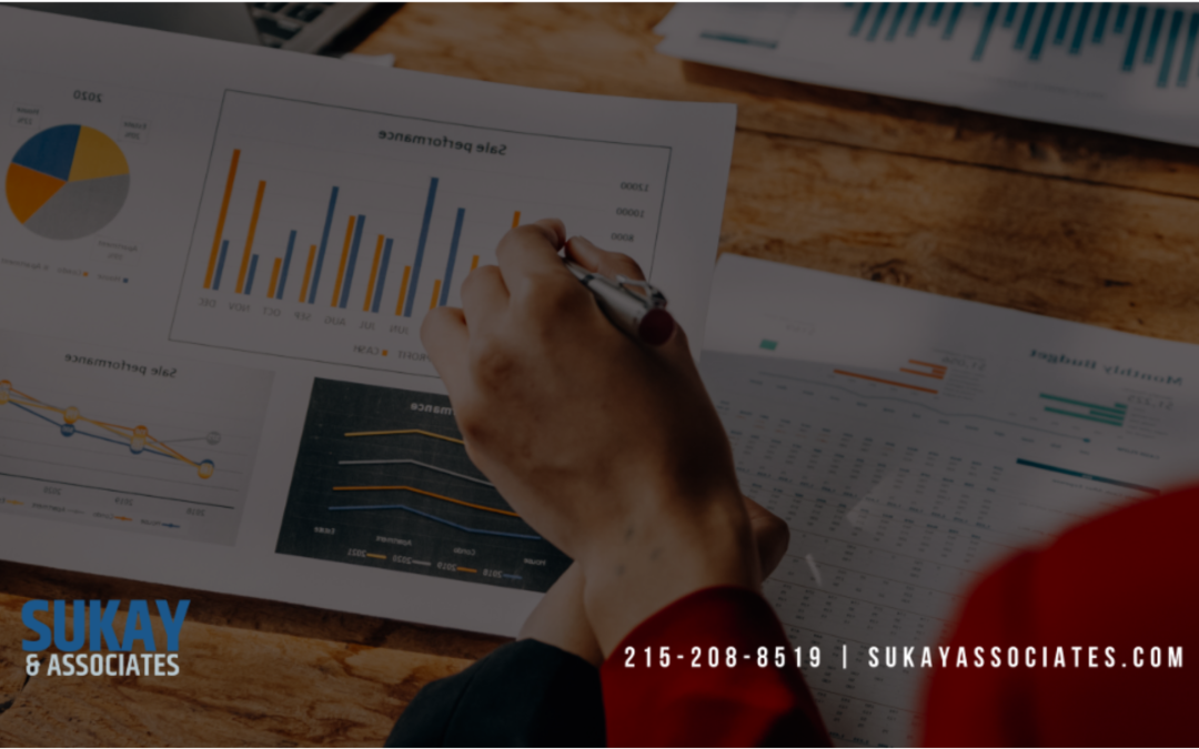 Insurance agency performance reports and sales charts being reviewed during year-end financial analysis.