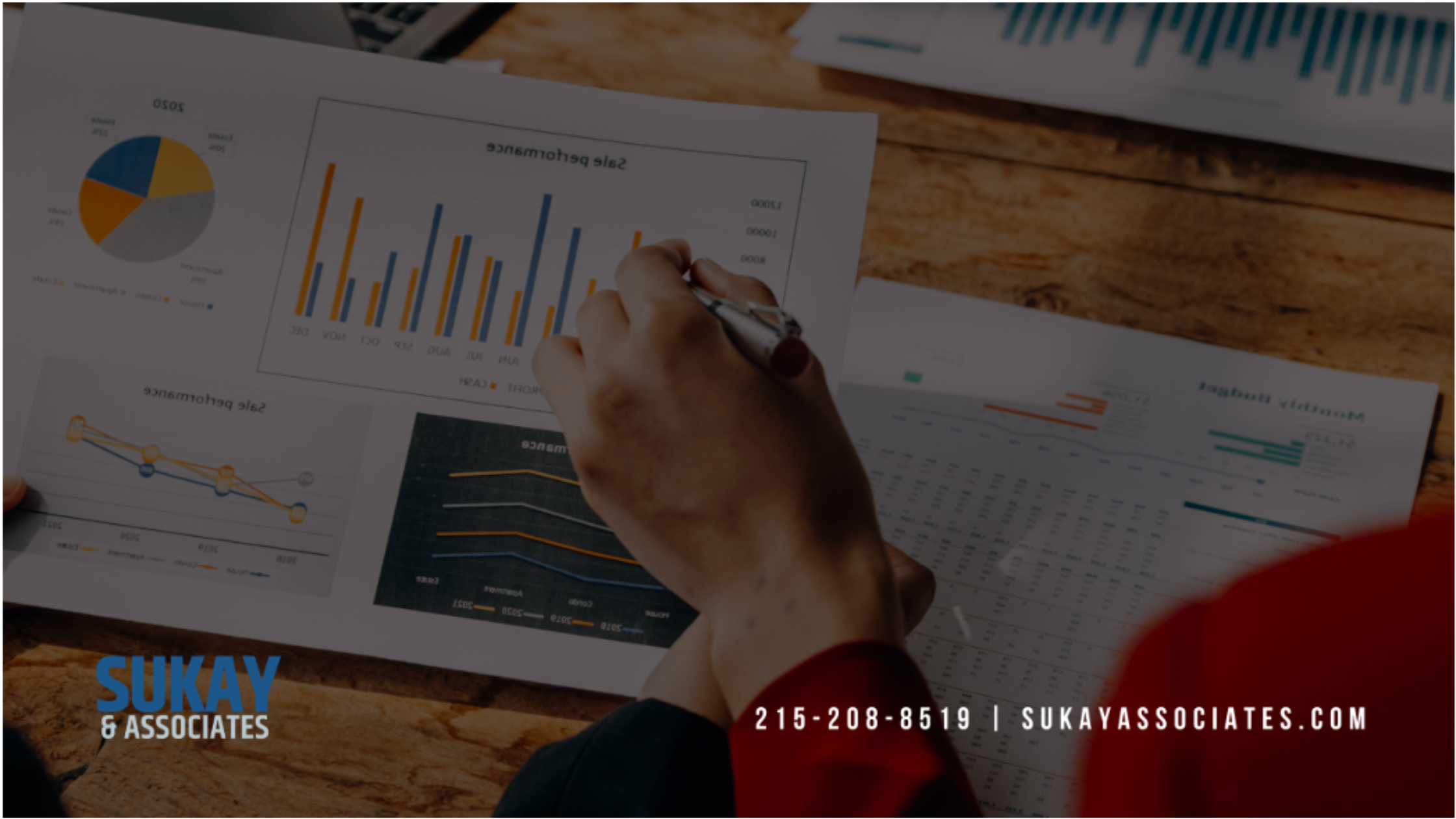 Insurance agency performance reports and sales charts being reviewed during year-end financial analysis.